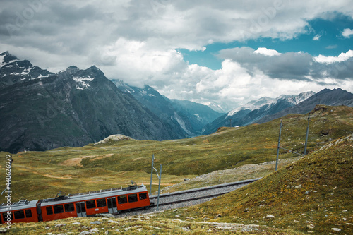 Railway in mountains and red train. Zermatt, Swiss Alps. Adventure in Switzerland, Europe. © svetakhovrina