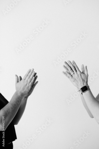 closeup of hands clapping or praying against white backdrop with empty space