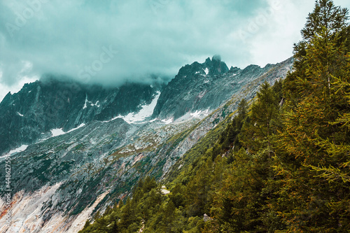 Mountains in Chamonix. Outdoor landscape with clouds and forest in french Alps. Adventure in Europe  France.