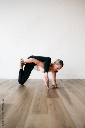 woman holding difficult flexible yoga pose