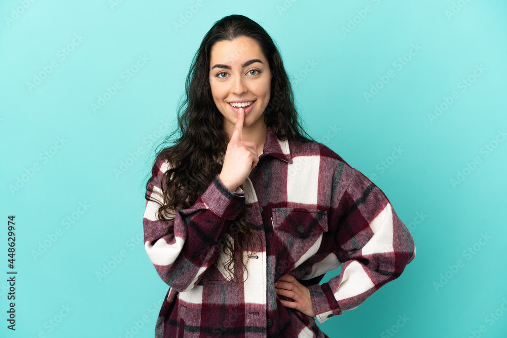 Young caucasian woman isolated on blue background showing a sign of silence gesture putting finger in mouth Young caucasian woman isolated on blue background showing a sign of silence gesture putting finger in mouth