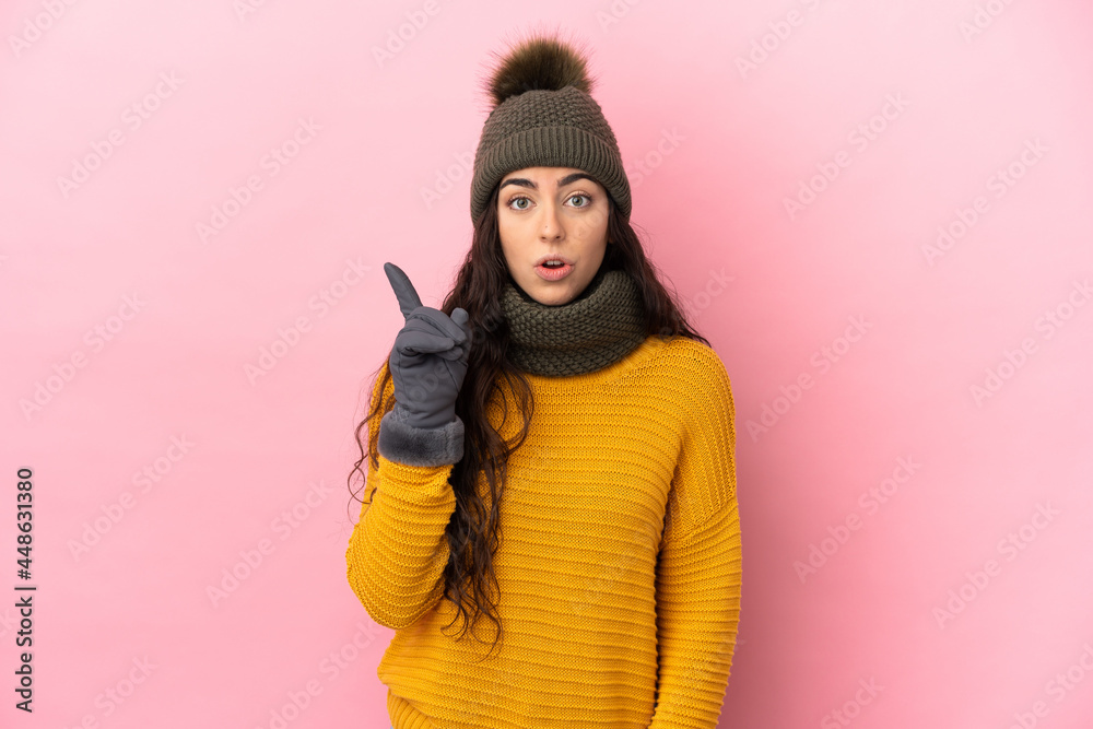 Young caucasian girl with winter hat isolated on purple background intending to realizes the solution while lifting a finger up Young caucasian girl with winter hat isolated on purple background intending to realizes the solution while lifting a finger up