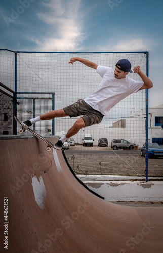 young man skateboarding on the ramp of a skate park. vertical composition