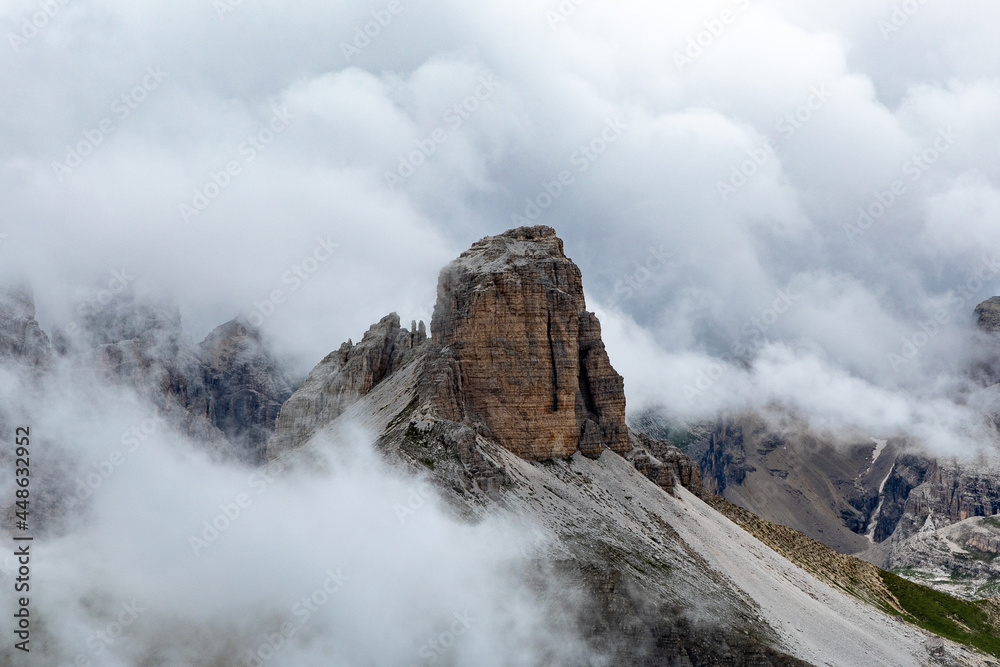 Dramatic mountain peak rising up in the clouds in the dolomites