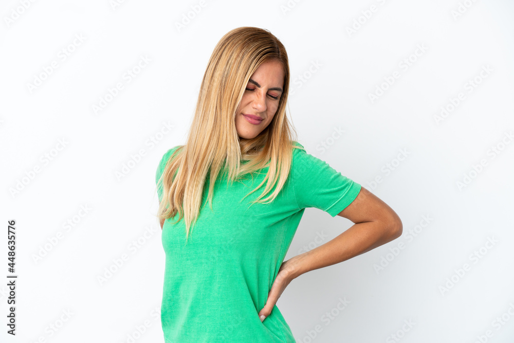 Blonde Uruguayan girl isolated on white background suffering from backache for having made an effort Blonde Uruguayan girl isolated on white background suffering from backache for having made an effort