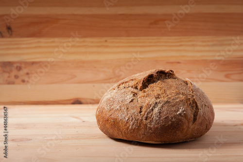 Handmade fresh wheat bread on wooden background in the morning light. horizontal frame side view with space area for text or design