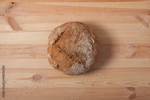 Handmade fresh wheat bread on wooden background in the morning light. horizontal frame top view with space area for text or design