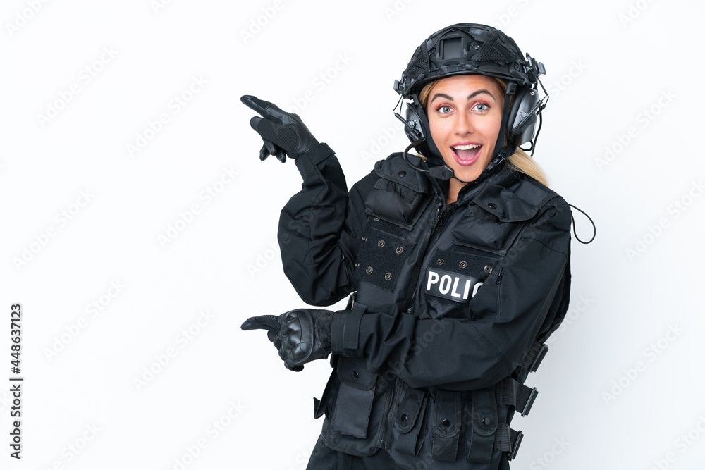SWAT caucasian woman isolated on white background surprised and pointing side SWAT caucasian woman isolated on white background surprised and pointing side