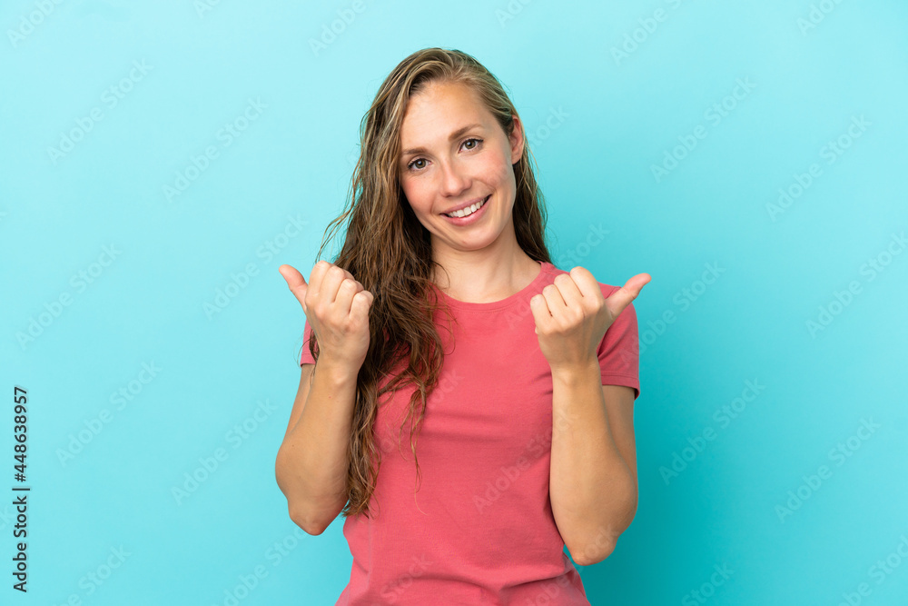 Young caucasian woman isolated on blue background with thumbs up gesture and smiling Young caucasian woman isolated on blue background with thumbs up gesture and smiling