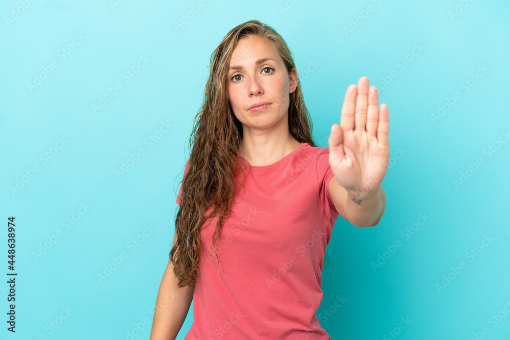 Young caucasian woman isolated on blue background making stop gesture Young caucasian woman isolated on blue background making stop gesture