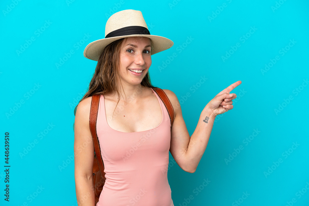 Young caucasian woman in summer holidays isolated on blue background pointing finger to the side Young caucasian woman in summer holidays isolated on blue background pointing finger to the side