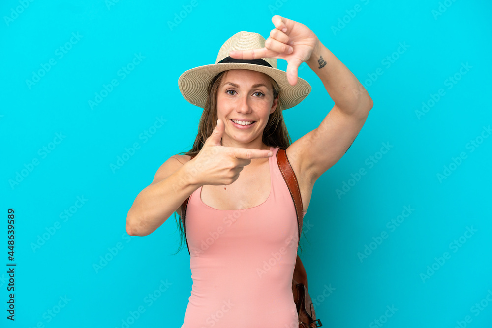 Young caucasian woman in summer holidays isolated on blue background focusing face. Framing symbol Young caucasian woman in summer holidays isolated on blue background focusing face. Framing symbol