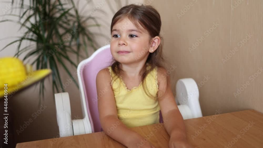 Happy little girl is waiting for corn. Mom bring fresh boiled corn for her adorable daughter Happy little girl is waiting for corn. Mom bring fresh boiled corn for her adorable daughter