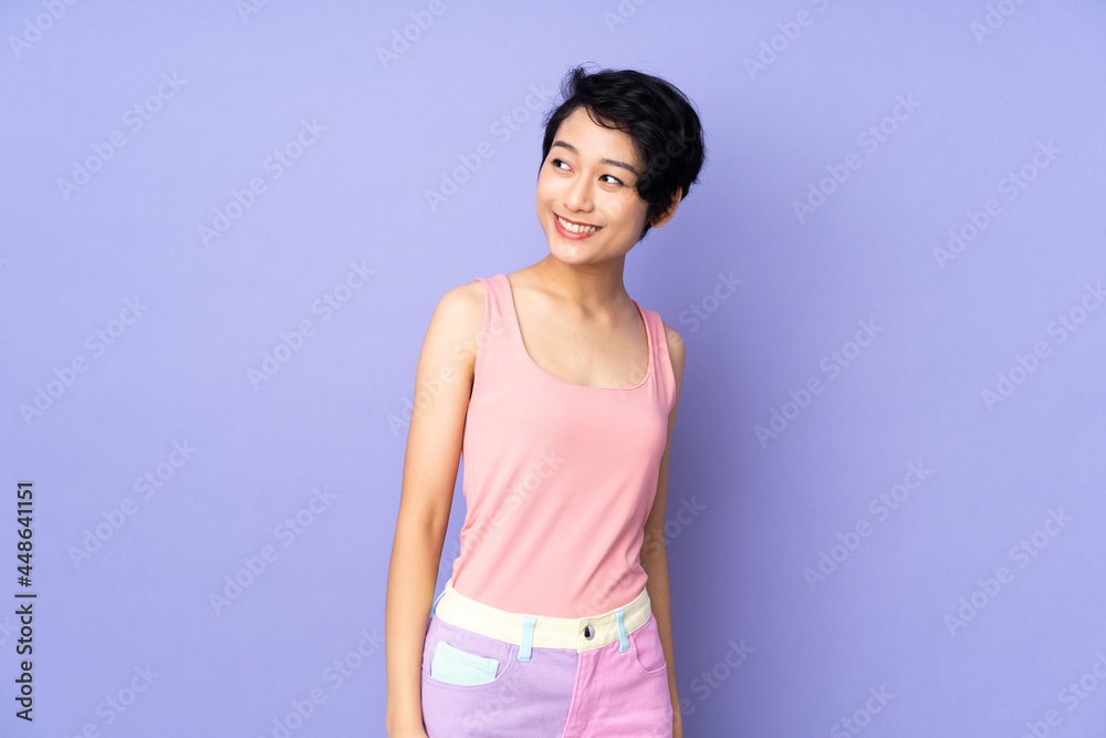 Young Vietnamese woman with short hair over isolated purple background looking to the side and smiling Young Vietnamese woman with short hair over isolated purple background looking to the side and smiling