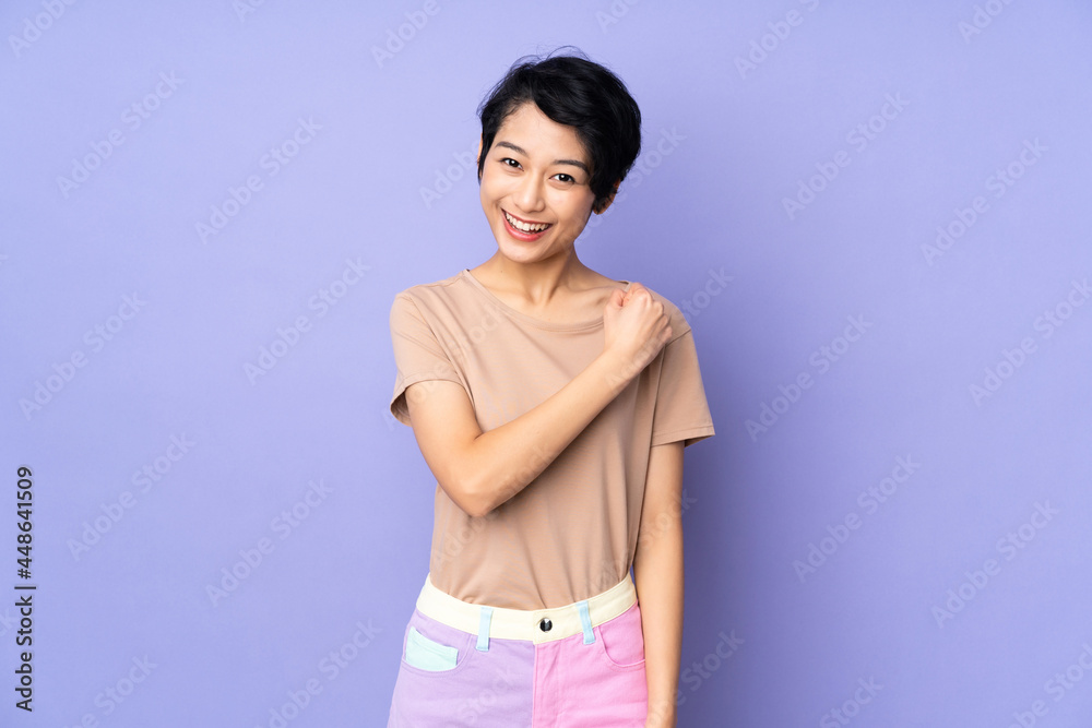 Young Vietnamese woman with short hair over isolated purple background celebrating a victory Young Vietnamese woman with short hair over isolated purple background celebrating a victory