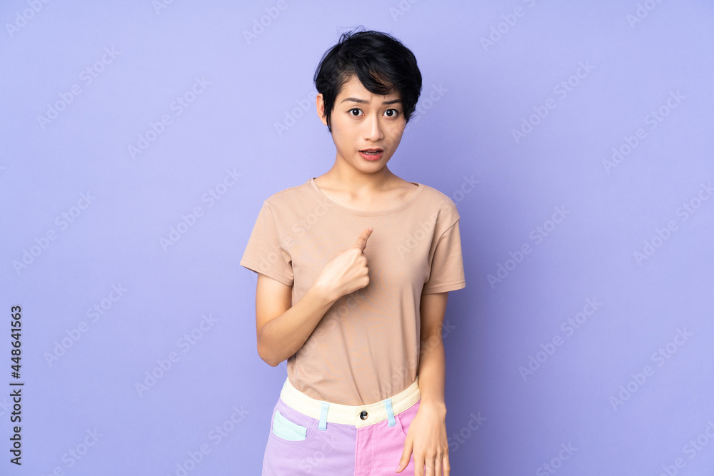 Young Vietnamese woman with short hair over isolated purple background pointing to oneself Young Vietnamese woman with short hair over isolated purple background pointing to oneself