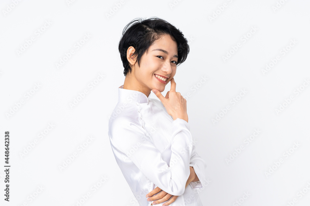 Young Vietnamese woman with short hair wearing a traditional dress over isolated white background happy and smiling