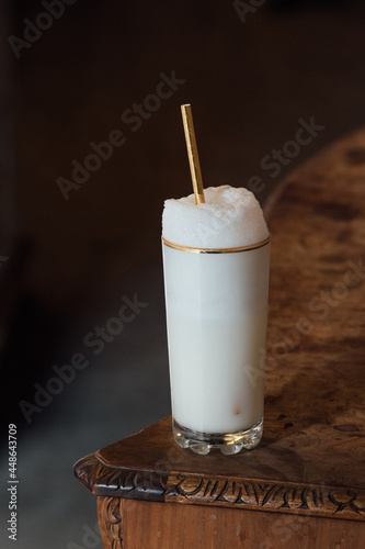 Billede på lærred Ramos gin fizz milkshake white foam in gold-rimmed tall glass with gold drinking