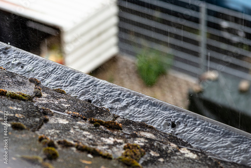 Photography Clogged gutter filled with water that overflows in rainy weather.