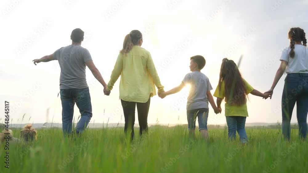 people in the park. happy family a silhouette walk in field. mom dad and fun daughters, son walk holding hands in park. happy family kid dream concept. parents and children walking back silhouette people in the park. happy family a silhouette walk in field. mom dad and fun daughters, son walk holding hands in park. happy family kid dream concept. parents and children walking back silhouette
