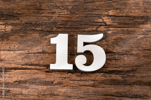 Number fifteen - White Piece on Rustic Wood Background photo