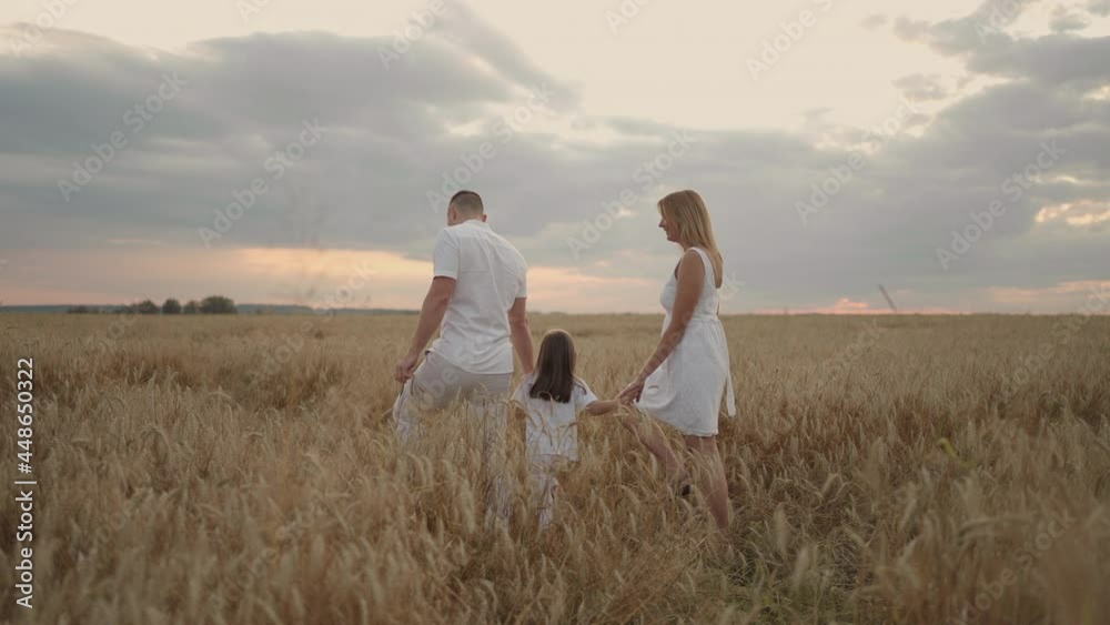 Slow motion: Happy family of farmers with child, are walking on wheat field. Healthy mother, father and little daughter enjoying nature together, outdoors. Slow motion: Happy family of farmers with child, are walking on wheat field. Healthy mother, father and little daughter enjoying nature together, outdoors.