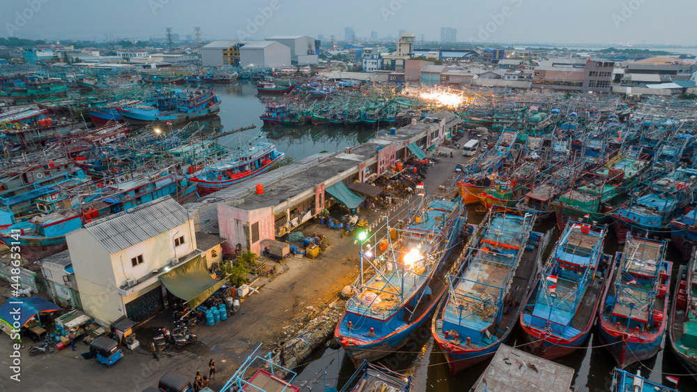 Obraz premium Aerial drone view of wooden boats leaning beside the pier. With noise cloud. Jakarta, Indonesia