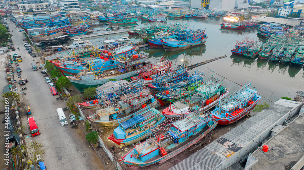 Aerial drone view of wooden boats leaning beside the pier. With noise cloud. Jakarta, Indonesia