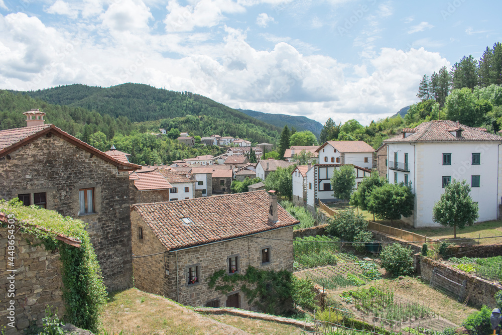 The photo shows a natural mountain landscape with a typical village in the north of Navarra, Spain.