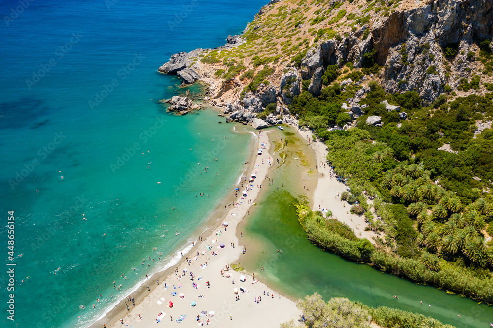 Aerial view of a beautiful palm tree forest leading to a sandy beach (Preveli, Crete)