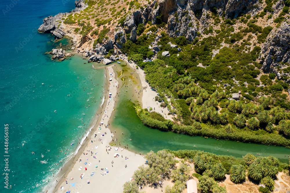 Aerial view of a palm forest and river leading to a clear blue ocean (Preveli, Crete, Greece)