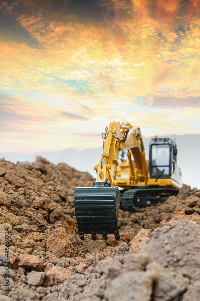 Obraz premium Selective focus ,Excavator with Bucket are digging the soil in the construction site on the sunset background