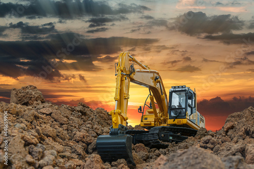 Crawler excavator digging the soil In the construction site on  sunset background photo