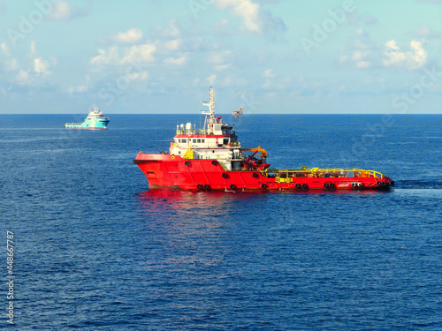 Supply boat transfer cargo to oil and gas industry and moving cargo from the boat to the platform. Boat is waiting transfer cargo and crews to platform.