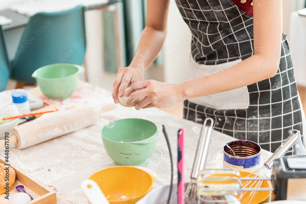 Happy woman in the kitchen. Woman preparing the egg in bowl, bake cookies. Happy woman in the kitchen. Woman preparing the egg in bowl, bake cookies.