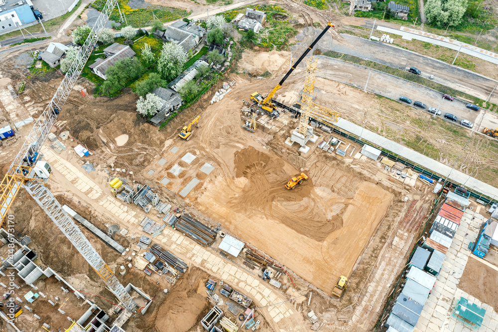 heavy industrial machines working on construction site. leveling and compaction of soil for construction of a new building. aerial view from flying drone. heavy industrial machines working on construction site. leveling and compaction of soil for construction of a new building. aerial view from flying drone.