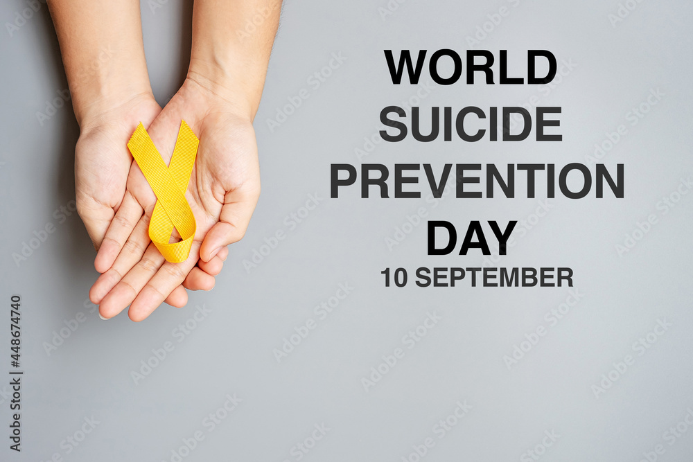 Obraz premium World Suicide prevention Day, hand holding Yellow Ribbon for supporting people living and illness