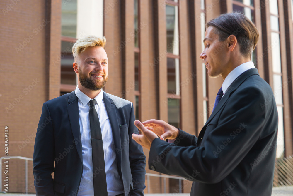 Confident businessman and his colleague in front of modern office building. Financial investors are talking outdoor. Banking and business. Confident businessman and his colleague in front of modern office building. Financial investors are talking outdoor. Banking and business.