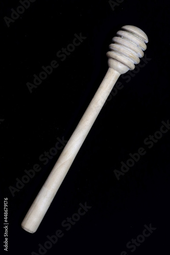 Full image of honey dipper in flat lay position on black background in HD size