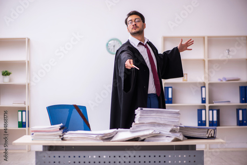Fotografie Funny young male employee magician and too much work in the office