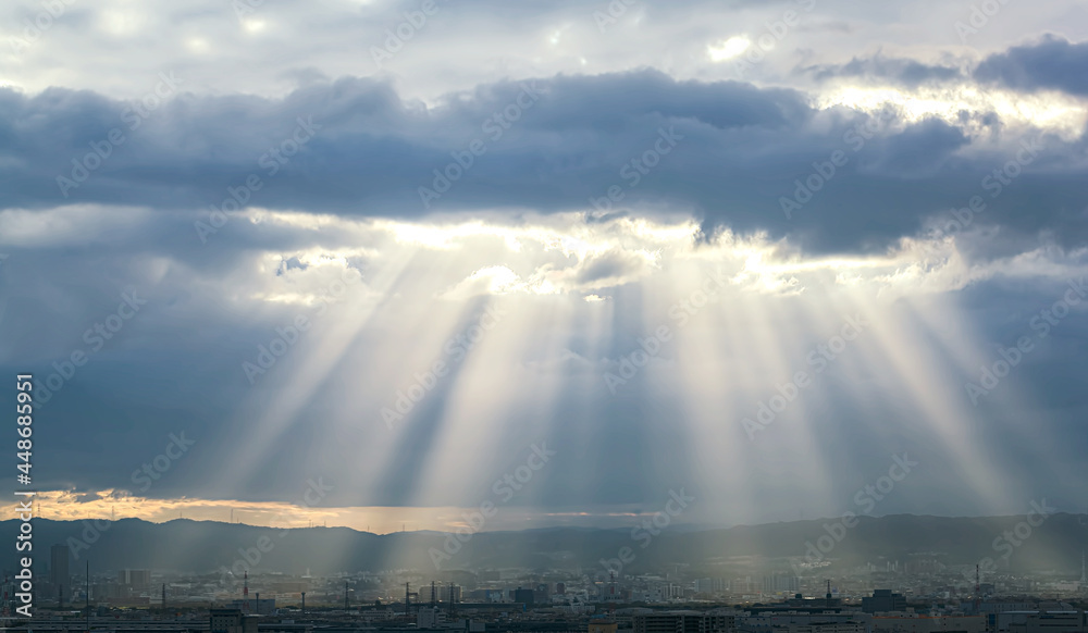 Obraz premium Dramatic crepuscular rays at sunrise in Osaka, Japan