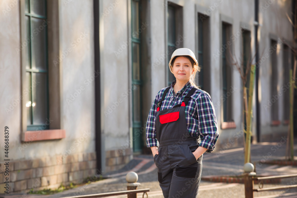 Young girl, manual worker posing outdoors with hands folded on chest