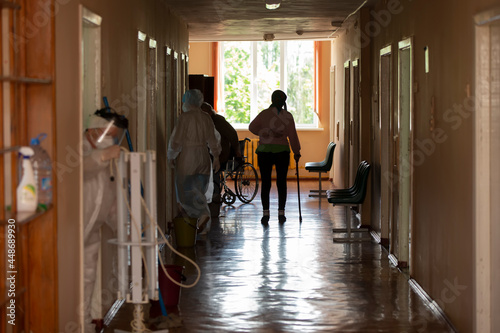 Hospital corridor with patients and doctors.