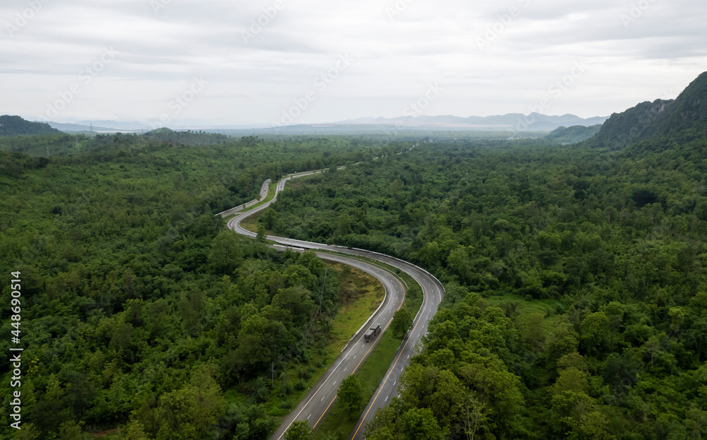 Top view of countryside road passing through the green forrest and mountain Top view of countryside road passing through the green forrest and mountain