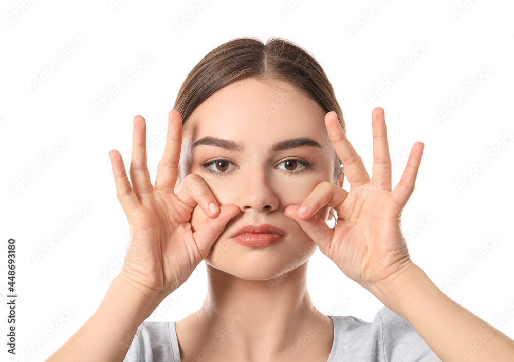 Beautiful young woman doing facial yoga on white background Beautiful young woman doing facial yoga on white background