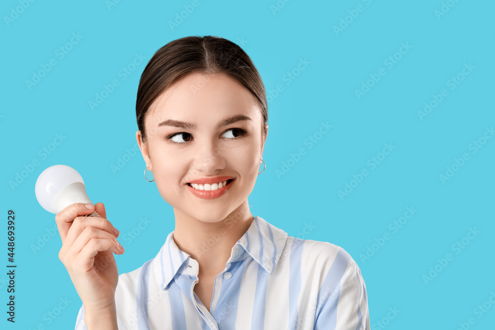 Young businesswoman with light bulb on color background Young businesswoman with light bulb on color background