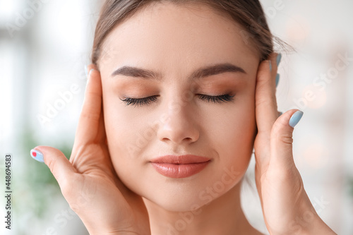 Young woman receiving face massage in beauty salon