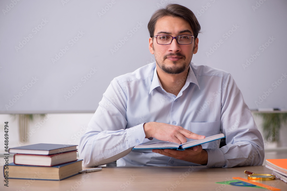 Young male teacher in front of whiteboard Young male teacher in front of whiteboard