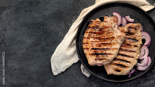 Sliced roasted pork meat on dark gray background. Organic gourmet food concept.