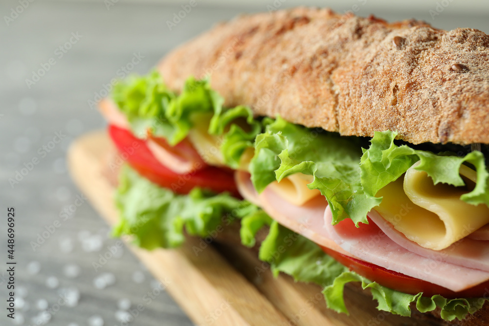 Board with ciabatta sandwich on gray textured table Board with ciabatta sandwich on gray textured table